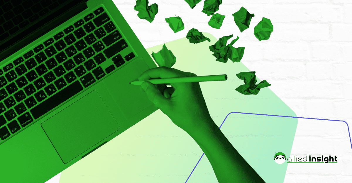 A person holding a pencil in front of a laptop.